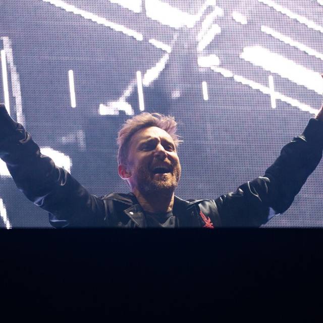 DJ David Guetta steht bei seinem Konzert anlässlich der Taufe für die neue AIDAnova an der Meyer Werft mit ausgestreckten Armen feiernd auf der Bühne.