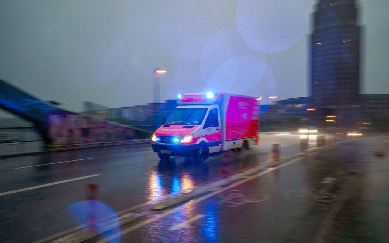 Ein Rettungswagen fährt bei Regen über eine Brücke