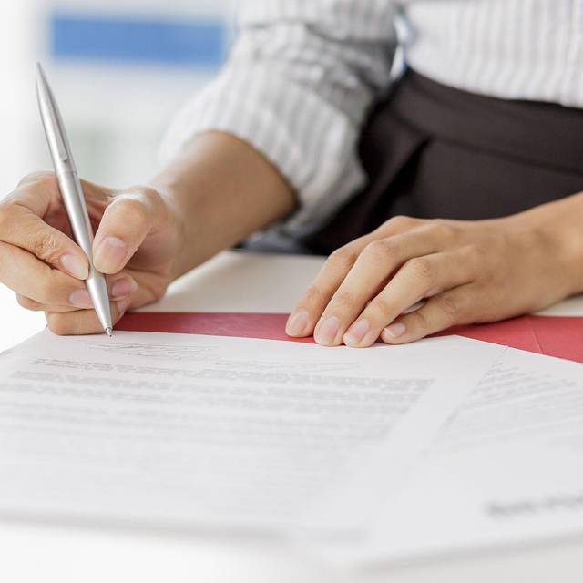 Frau unterschreibt ein Arbeitszeugnis
