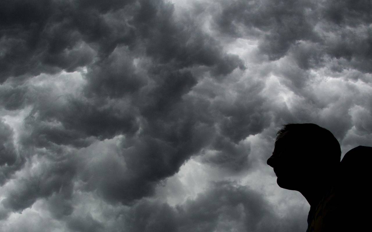 Ein Mann steht unter einem stürmischen Himmel