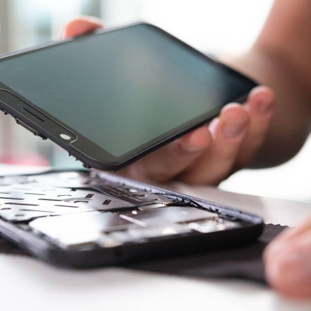 Mann baut ein Smartphone auseinander