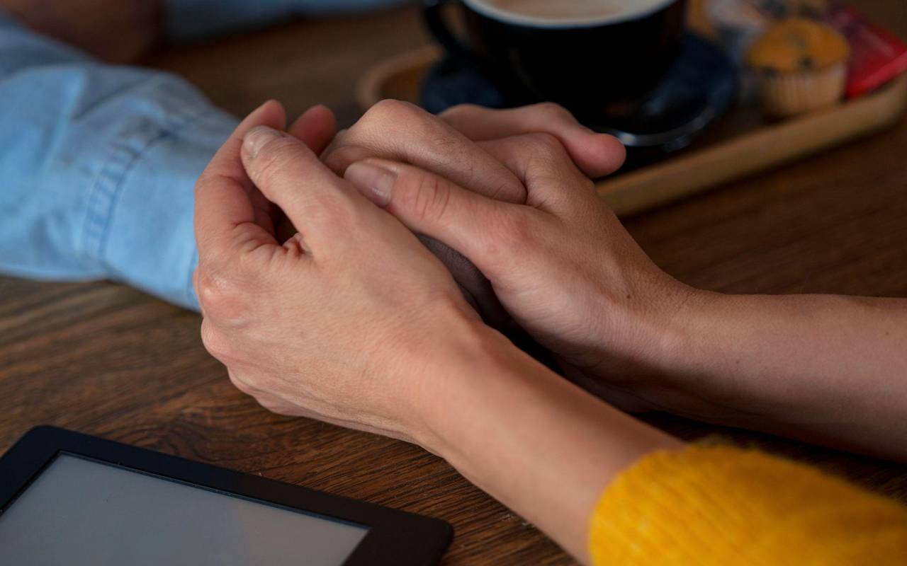 Zwei Personen halten sich an den Händen