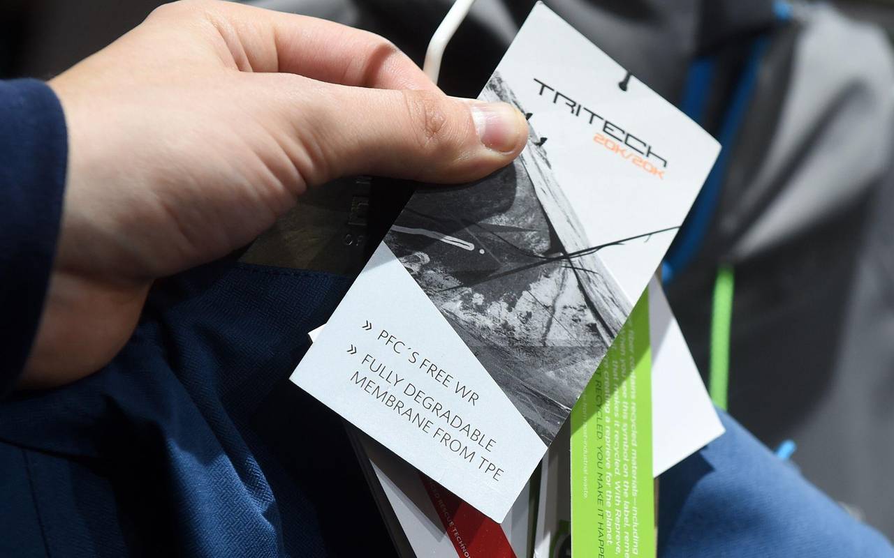 Ein Mann hält ein PFC-frei-Etikett an einer Sportkleidung