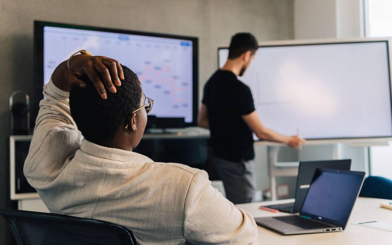 Eine Faru fasst sich an den Kopf in einem Meetingraum