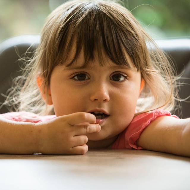 Ein Mädchen steckt sich etwas in den Mund