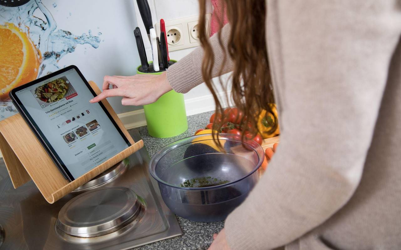 Eine Frau nutzt ihr Tablet in der Küche