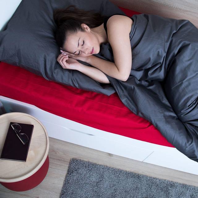 Frau schläft in einem Bett