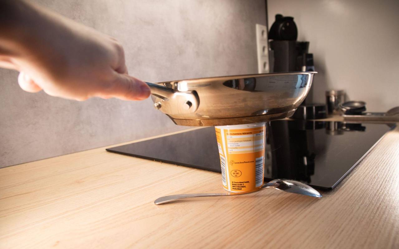 Heiße Pfanne wird auf einen Becher Schmand gestellt