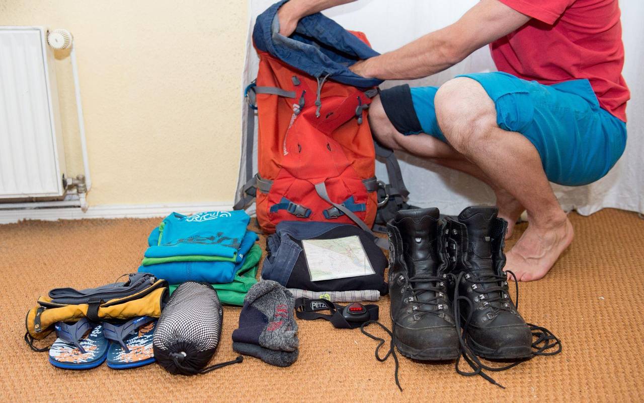 Ein Mann packt einen Wanderrucksack