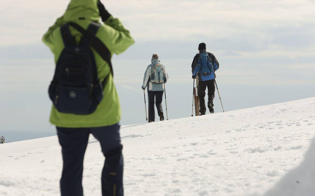 Wanderer gehen über den schneebedeckten Brocken