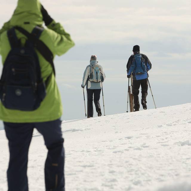 Wanderer gehen über den schneebedeckten Brocken