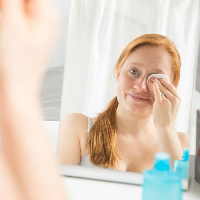 Eine Frau schminkt sich ab