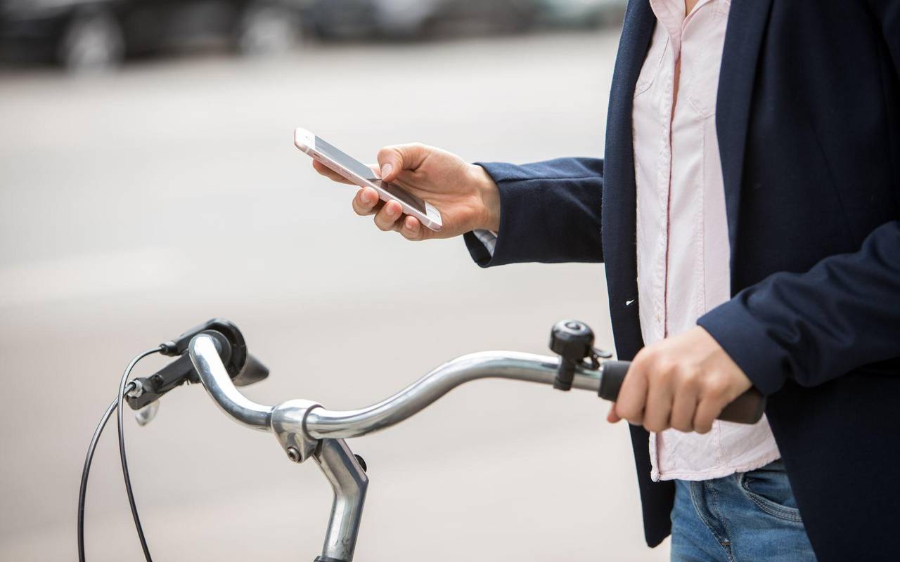 Eine Frau mit Smartphone und Fahrrad