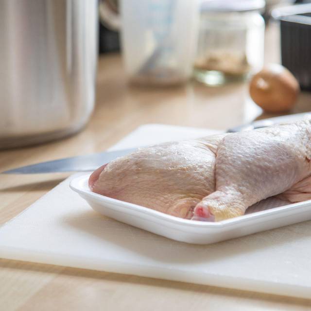 Rohe Hähnchenschenkel liegen in einer Kunststoffschale