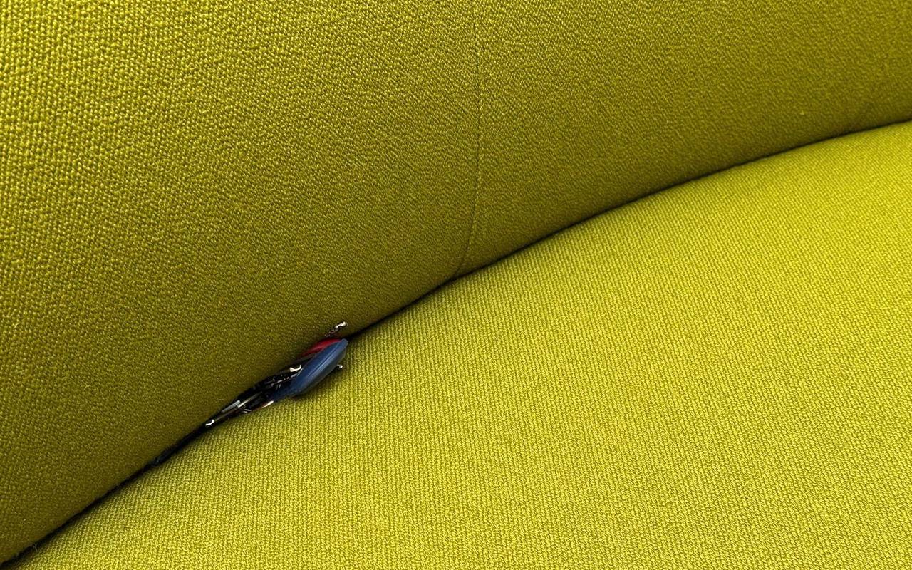 Schlüssel mit einem Airtag liegt in einer Sofaritze