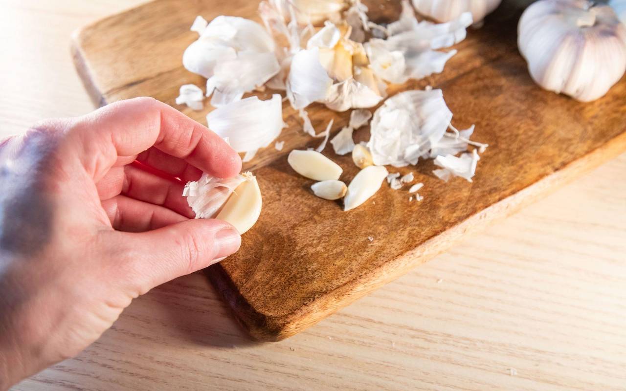 Frau pellt Knoblauchzehen