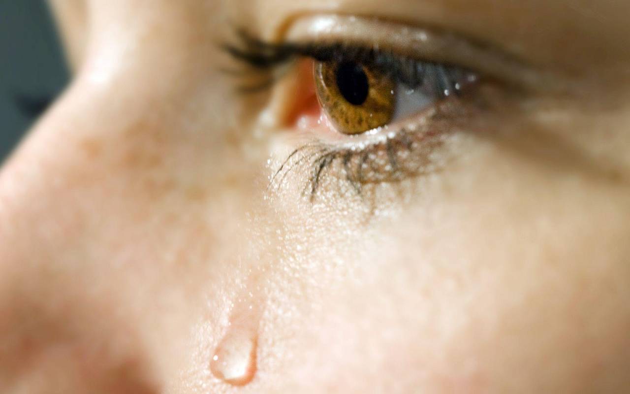 Träne rollt über die Wange einer Frau