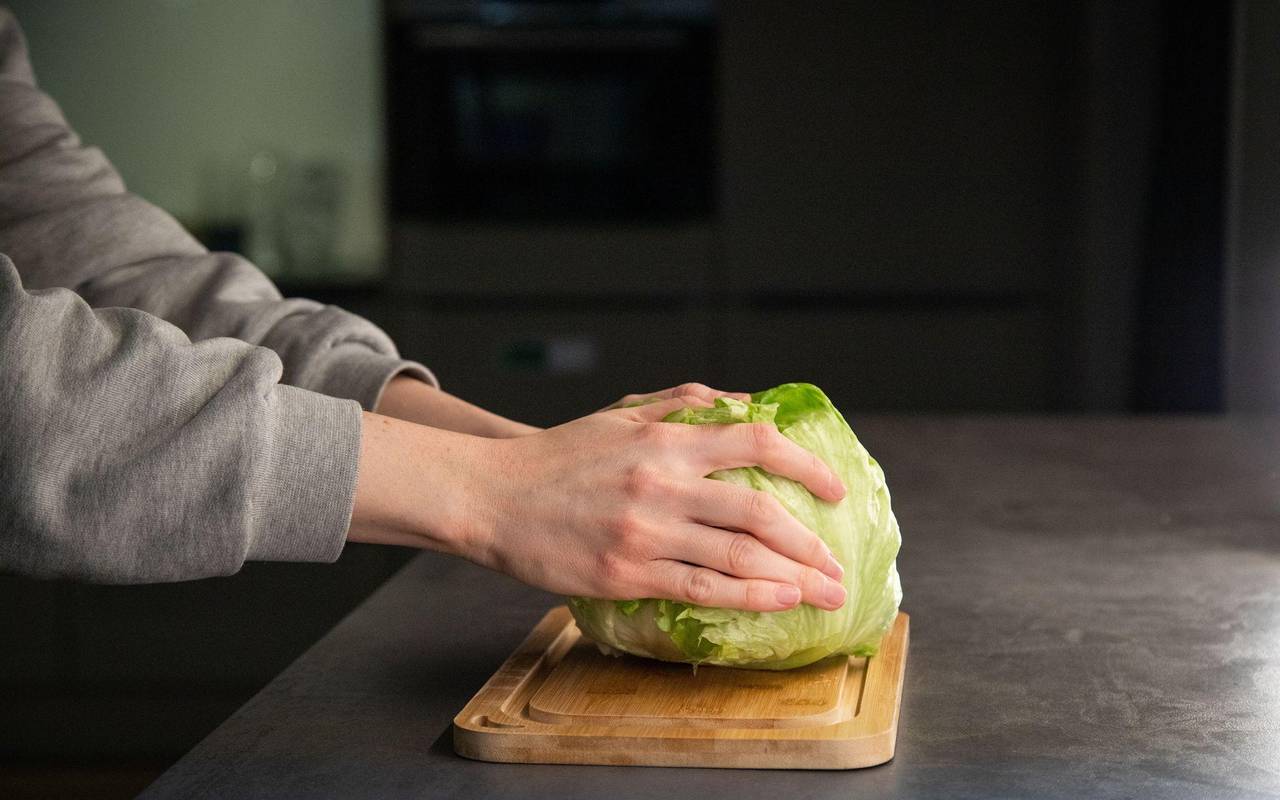 Salat liegt mit dem Strunk nach unten auf einer Arbeitsfläche