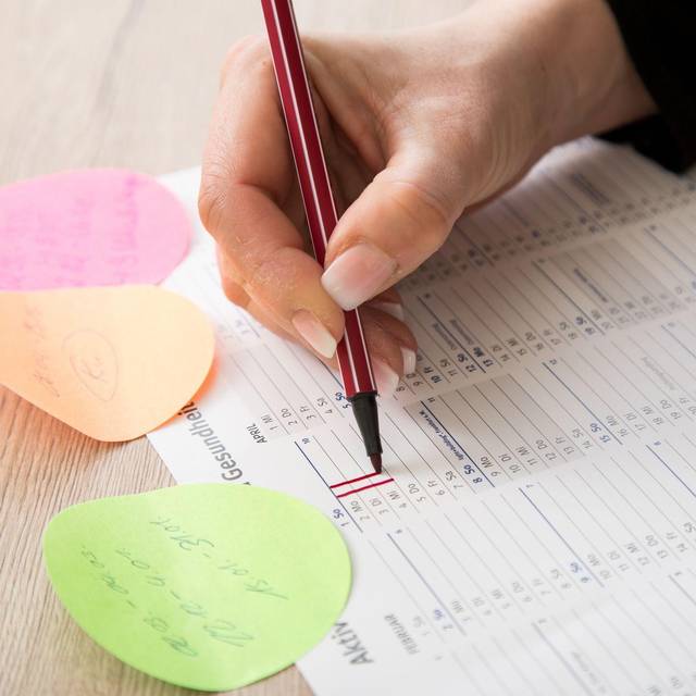 Eine Frau makiert Urlaubstage in einem Kalender