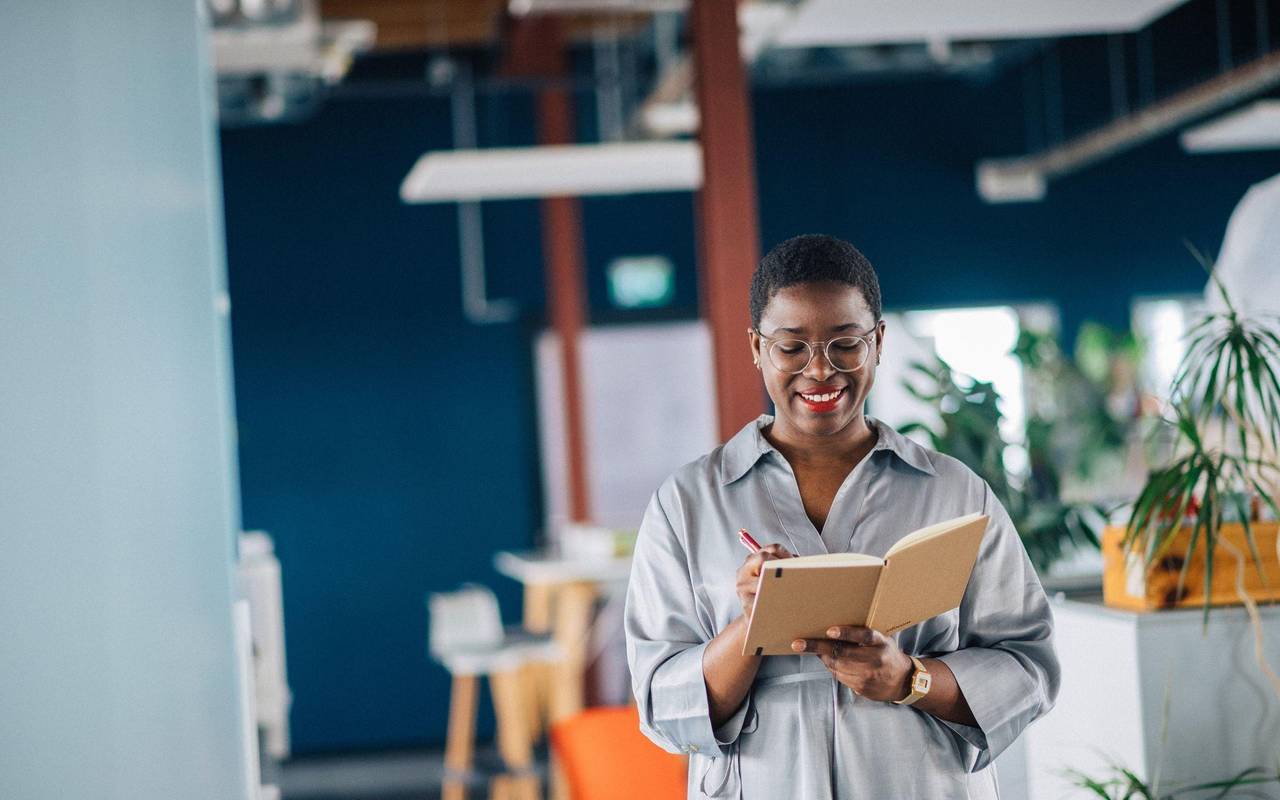 Eine junge Frau schreibt in ein Notizheft