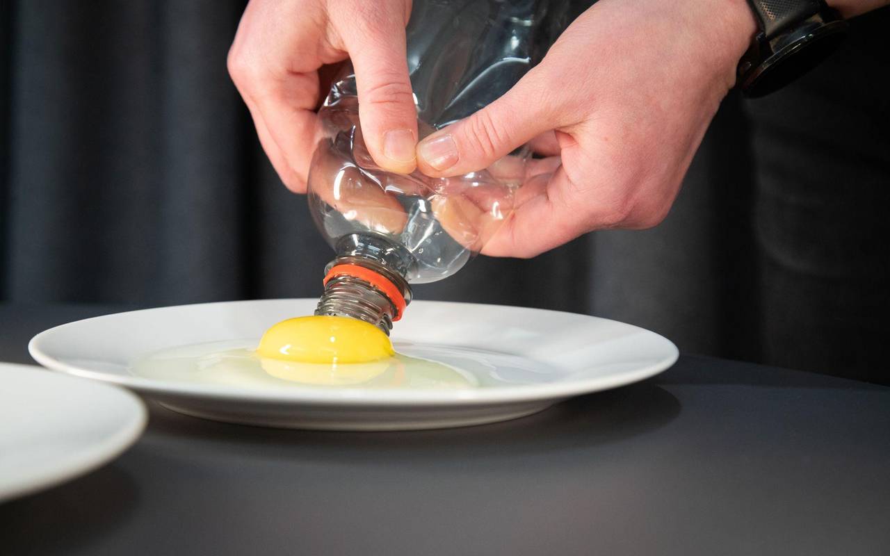 Flasche wird zusammengedrückt, um Eigelb von Eiweiß zu trennen