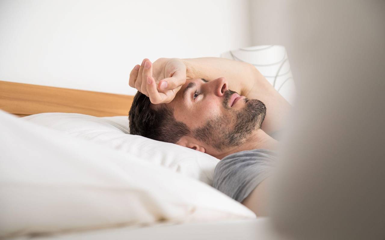 Ein junger Mann liegt im Bett