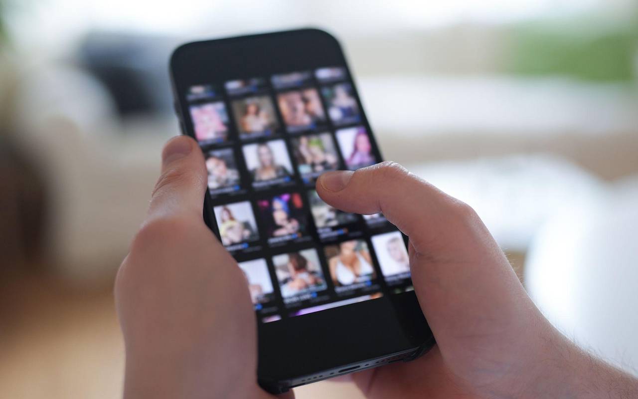 Mann schaut sich Videos auf einem Smartphone an