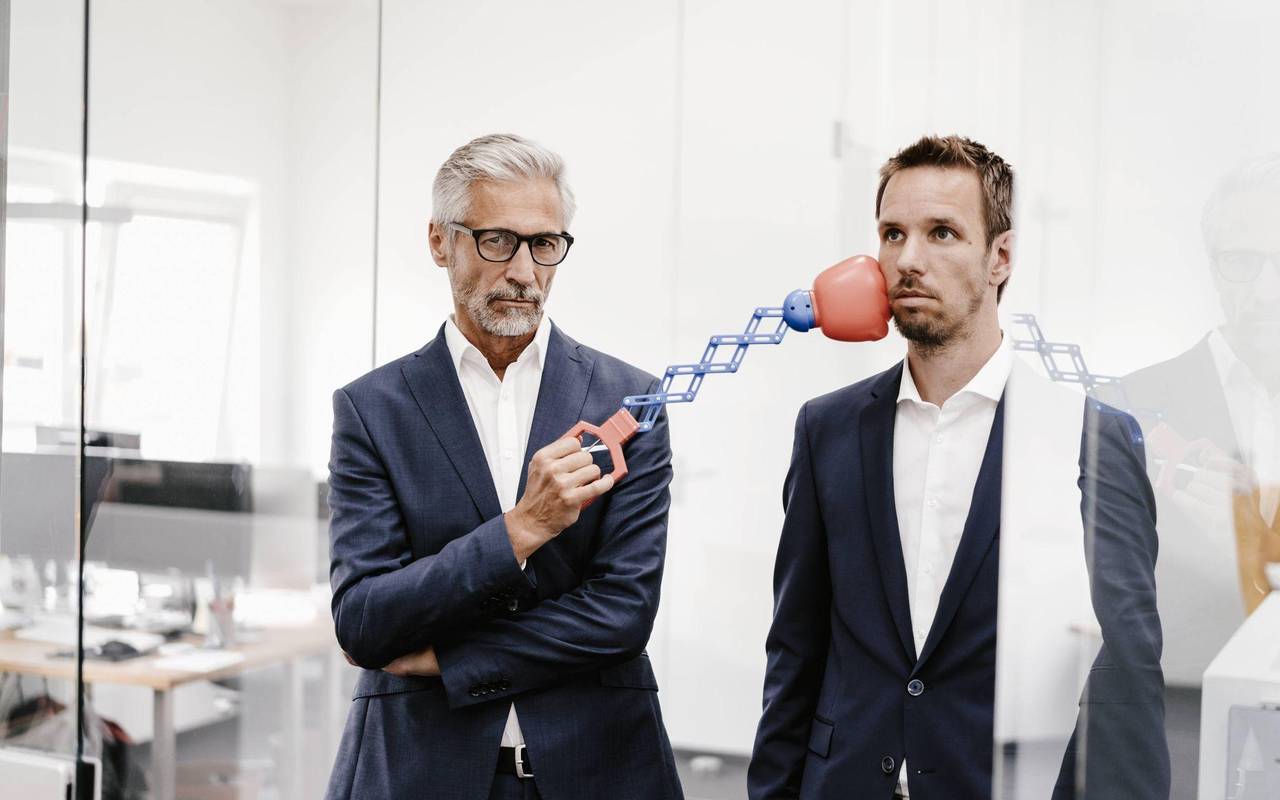 Ein Mann trfft einen Kollegen mit einem Boxspielzeug am Kinn