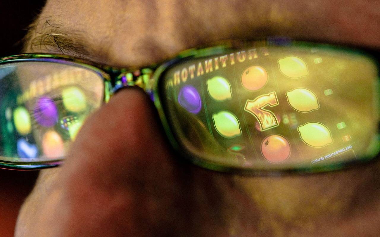 Symbole eines Spielautomaten spiegeln sich in einer Brille