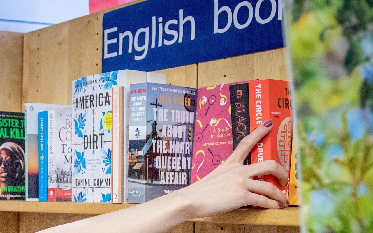 Eine Frau entnimmt ein Buch aus einem Regal