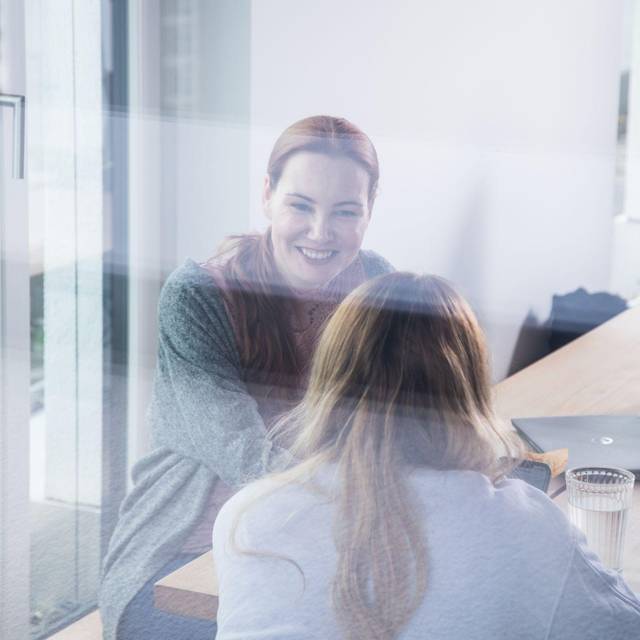 Zwei Frauen unterhalten sich in einem Pausenraum