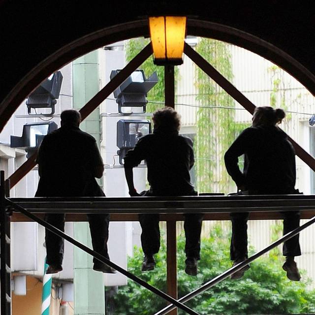 Arbeiter sitzen auf einem Baugerüst