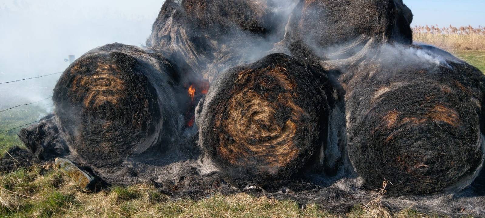 Strohballen und Feld in Flammen