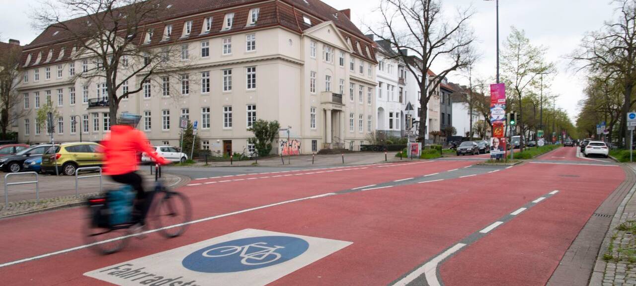 Eine Fahrradfahrerin fährt durch eine deutsche Innenstadt. Sie erhält dabei freie Fahrt, da sie eine eigene Spur bekommt.