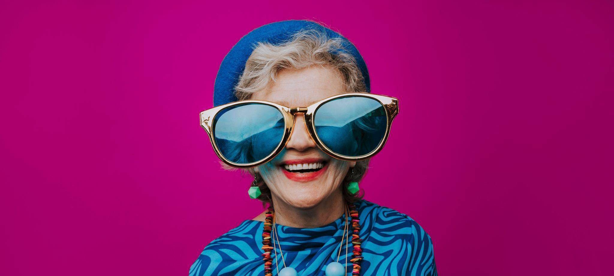 Eine glückliche Seniorin mit übergroßer Sonnenbrille