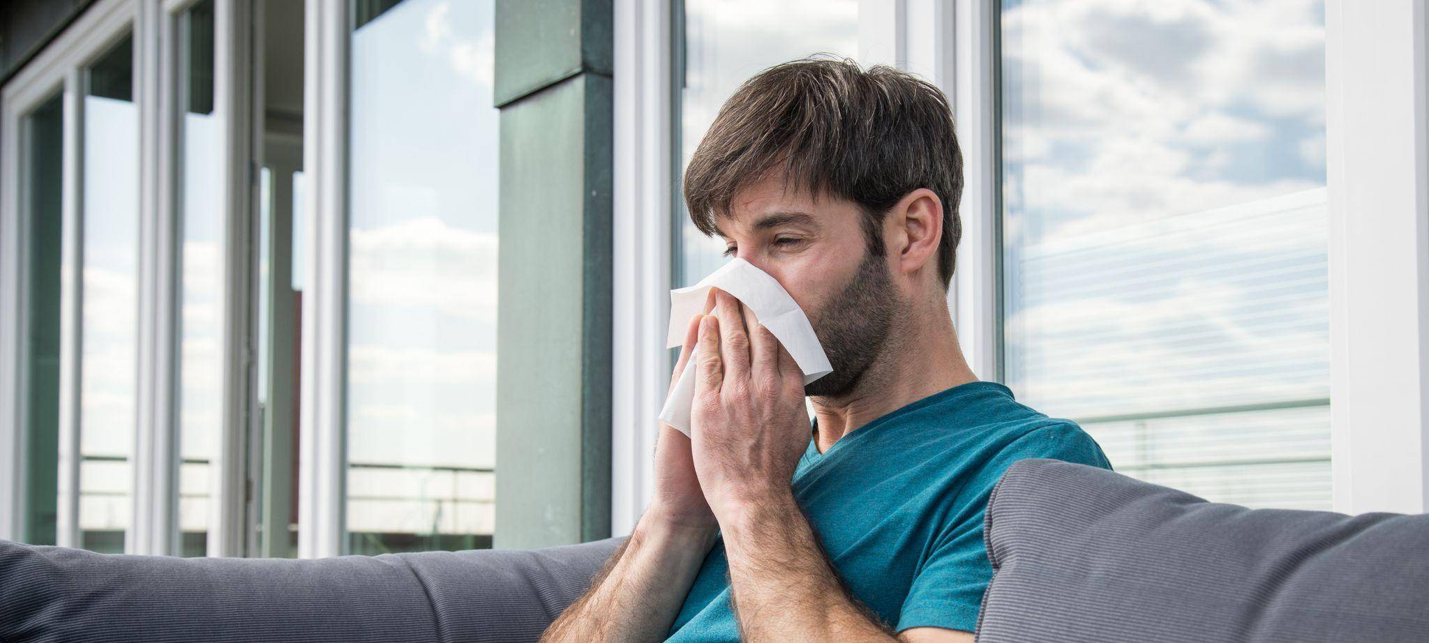 Ein Mann putzt sich die Nase