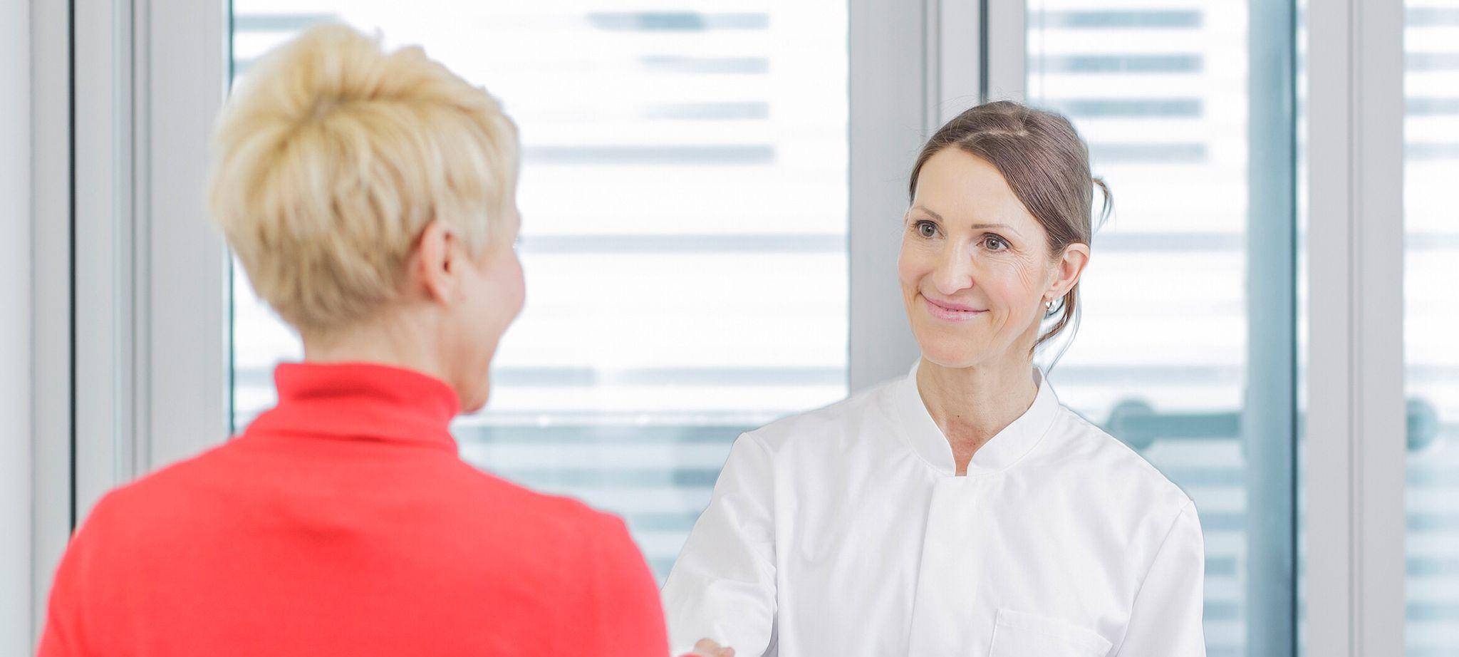 Ärztin begrüßt eine Patientin