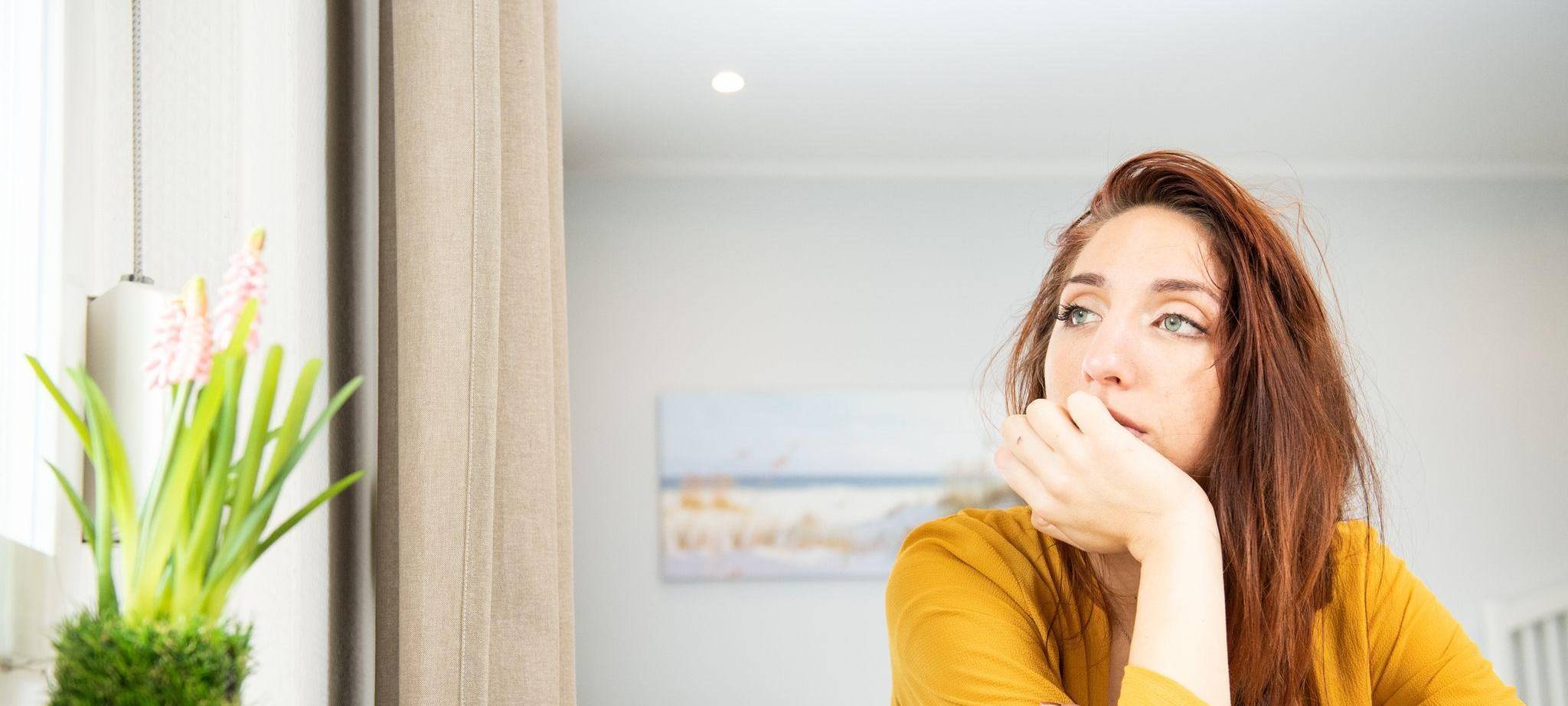 Eine junge Frau schaut aus dem Fenster