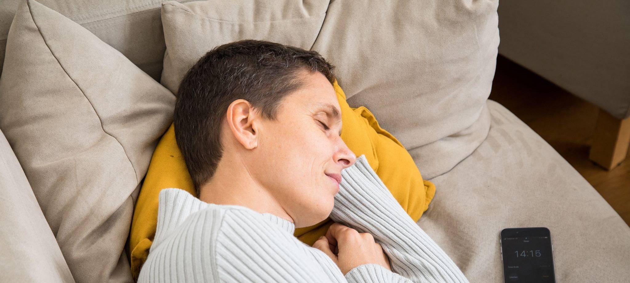 Eine Frau schläft auf einem Sofa
